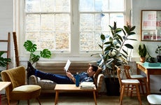 A man reclines on his sofa with a laptop computer